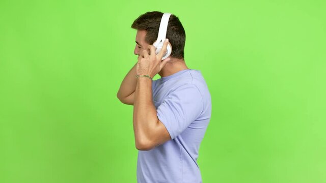 Handsome man listening to music with headphones over isolated background