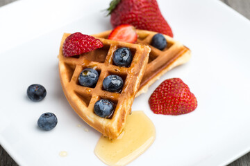 Waffles with blueberries, strawberries and honey