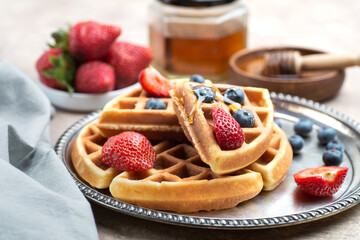 Waffles with blueberries, strawberries and honey