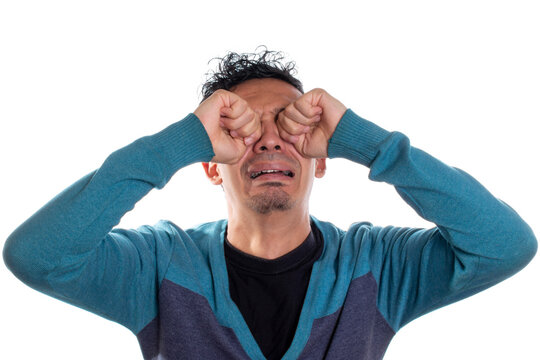 Young adult young man crying, isolated on white background. Man crying with hands on face.
