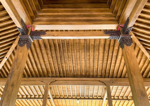 The ceiling of a joglo house, a traditional Javanese house, Indonesia, made of high grade teak wood and handmade carvings