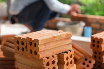 Bricklayer industrial worker installing brick masonry on exterior wall with trowel putty knife.