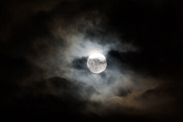 Full moon known as Hunter's Moon visible bright amidst dark clouds