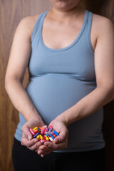 pregnant women holding pills in her hands