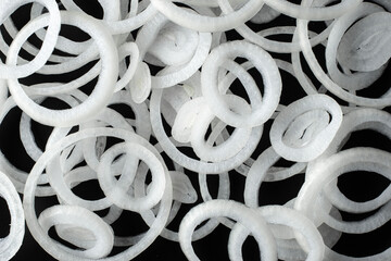 onion sliced into rings on a black background
