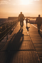 Silhouette of people walking along the promenade in the evening