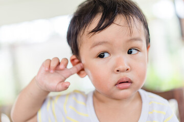 Little asian toddler baby boy has earache when insects inside outdoor baby infant boy hands...