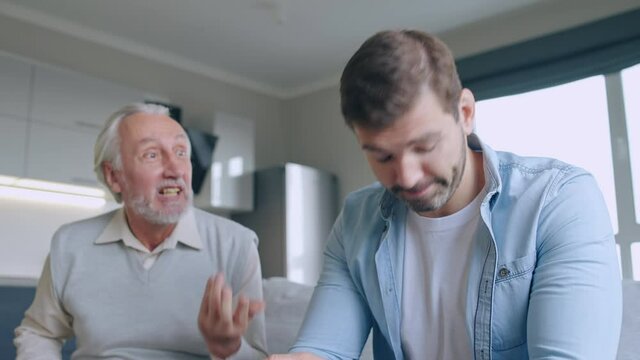 Elderly father shouting at son, conflict between generations, misunderstanding
