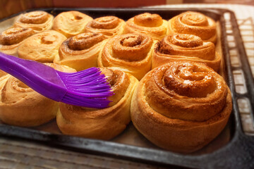 homemade buns on a baking sheet and pastry brush.
fresh baking concept
