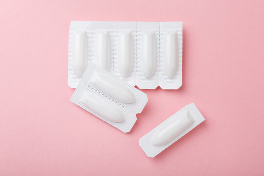 vaginal suppositories on pink background. Top view. Treatment of vaginal infections from sexually transmitted infections. Woman health. Contraception, birth control. Planning pregnancy