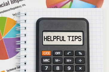 On the table are charts, a notebook and a calculator with the inscription - Helpful Tips
