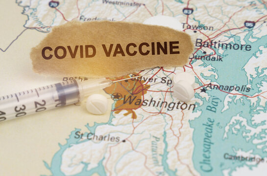 A syringe, pills and paper with the inscription - COVID VACCINE