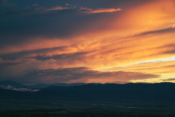 Mountain sunset with orange clouds