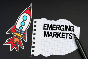 On a black background, a rocket, a marker and paper with the inscription - EMERGING MARKETS