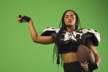 woman with sportswear, american football, shoulder pads, ball and braids