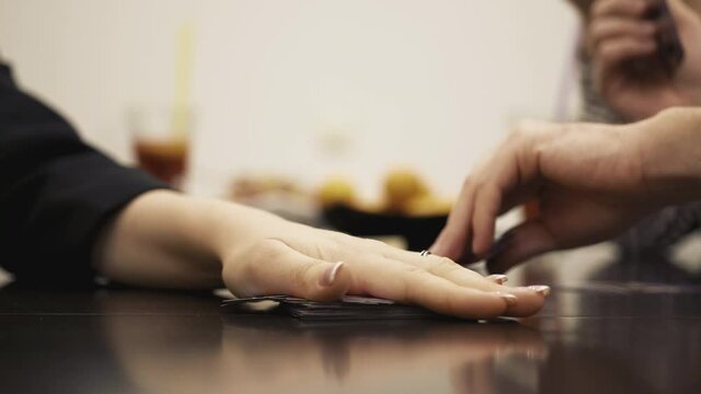 People stack hands while playing card boardgame. Close up. Slow mo