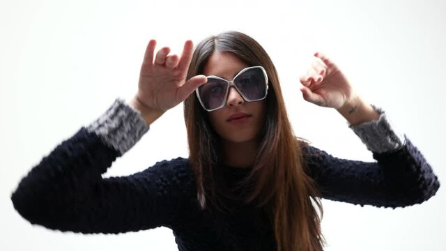 Woman posing and dancing in knitwear and shades
