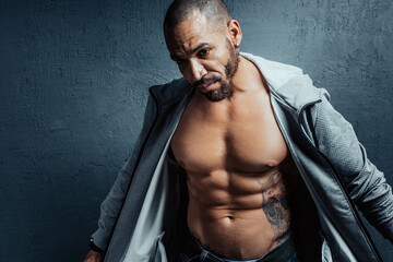 A brutal middle-aged man opened a sports jacket. Muscular body and cubes of the press on the...