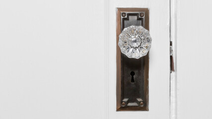 Beautiful crystal clear antique door knob on white painted door. Copy Space.