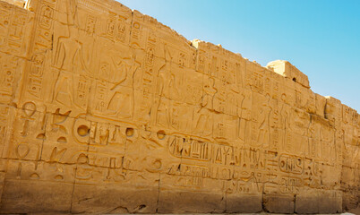 Ancient wall engraved with the figures of Egyptian pharaohs and gods in Egypt