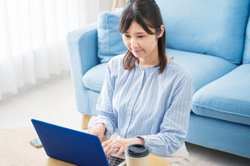 部屋でパソコンを使う女性
