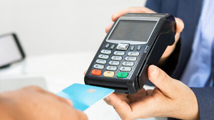 Customer hand paying by credit card. Focus on hands. 