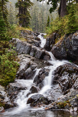 Fototapeta na wymiar waterfall in the mountains at snow lake