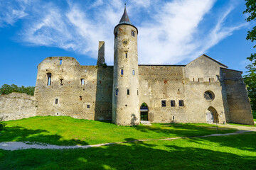 Obraz premium Medieval castle with high tower with clock and white clouds in sunny day. Haapsalu Estonia.