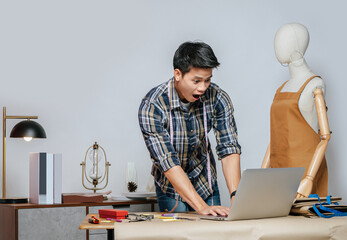 Young male designer use laptop computer while working