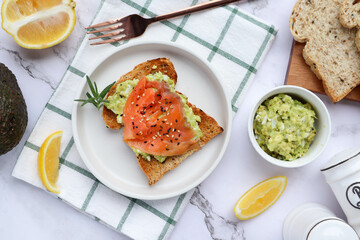 Toast with avocado and smoked salmon - Flat lay with some ingredients on marble table