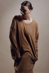 Attractive fashion girl with freckles face and nude makeup in cozy knitted autumn dress posing in studio