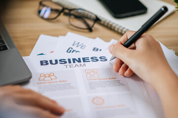 Female hand use pen to write on paper work