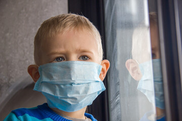 Kid using the medical face mask at hospital . Protection against corona virus. Sick child breathes...