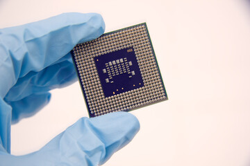 Hand in a blue glove holds pcb chip assembly on pcb backround on the production of printed circuit...