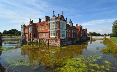 Helmingham Hall with moat bridges and reflections.