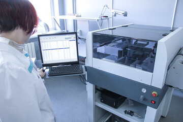 Woman controls automated soldering machine. Factory for the electronic production. Technological process of soldering and assembly chip components on pcb board.