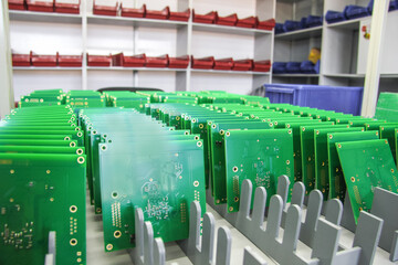 Production and assembly of pcb and chips in a factory. Boards are in a row. - obrazy, fototapety, plakaty