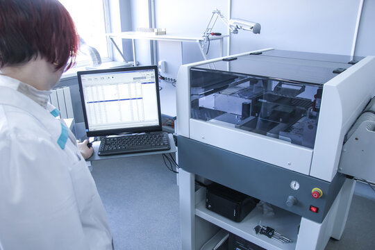 Woman controls automated soldering machine. Factory for the electronic production. Technological process of soldering and assembly chip components on pcb board.