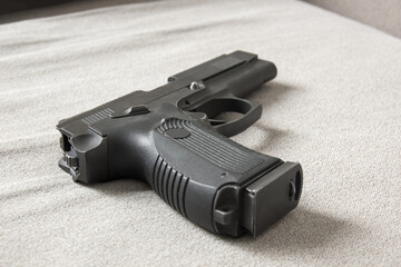 A gun in the house on the couch. Domestic violence concept