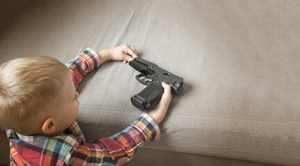 Child abuse, dysfunctional family, parenting problems,kid plays with a pistol, firearms. Gun in...