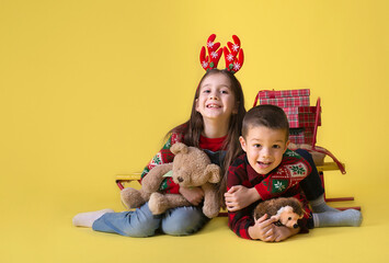 Kids with gifts on a yellow background for the Christmas holidays