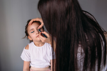 mom and daughter are at home, mom makes her daughter hair-curls, daughter is very happy