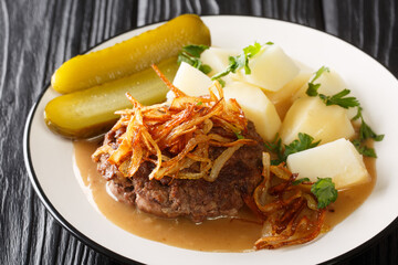 Danish Hamburger patties with gravy and Soft Onions with potatoes garnish close up in the plate on the table. Horizontal
