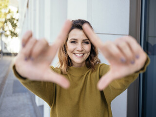 Happy friendly woman making a frame gesture around her face