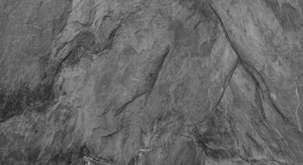 Abstract dark grey black slate background or texture. Close-up. Light gray rock backdrop.