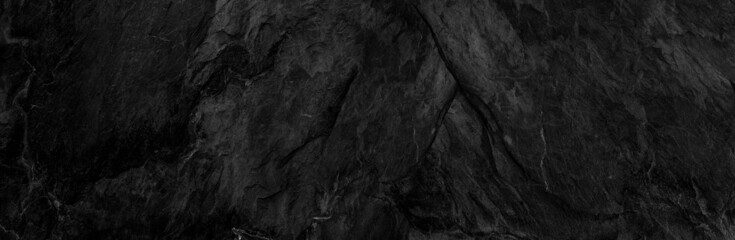 Panorama dark gray stone background with copy space. Black grunge banner with rock texture.