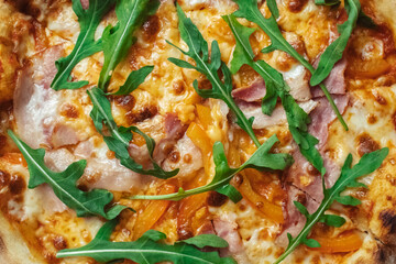 Close-up of pizza with bacon in a disposable dish. Top view of takeaway food in a fast food cafe. On photo - mozzarella cheese, tomatoes, and red basil. Classic recipe