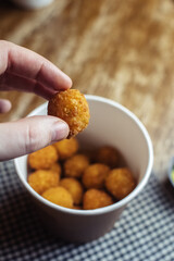Close-up of potato balls prepared in a fast food restaurant. Barizl national cuisine. Food in a cardboard box. Takeout food. Round buns with potatoes and cheese.