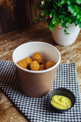 Close-up of potato balls prepared in a fast food restaurant. Barizl national cuisine. Food in a cardboard box. Takeout food. Round buns with potatoes and cheese.