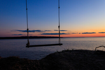 Rope swing on a shore of the Dnieper river in Ukraine at sunset